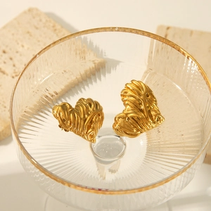 Vue détaillée de boucles d'oreilles cœur dorées avec texture ondulée unique