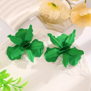 Detailed close-up of vibrant green layered flower earrings with a glossy lacquered finish
