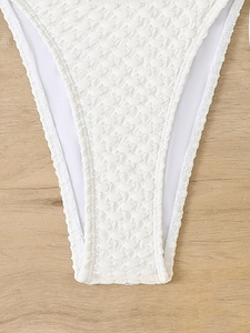 Macro shot of white textured bikini bottom fabric showing smocked fabric and stitching details