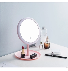 Detail view of pink round LED makeup mirror with storage tray and touch sensor button