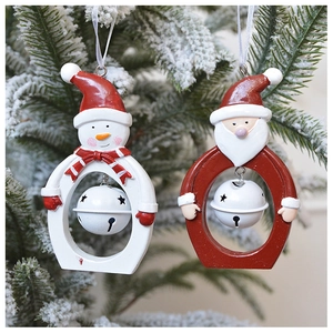 Detail showing Santa Claus and snowman ornaments with bells on a snowy Christmas tree