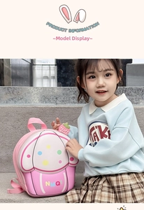 Detail view of pink cupcake toddler backpack with strawberry charm and polka dot pattern
