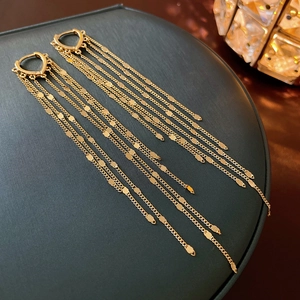 Elegant gold heart long chain tassel earrings displayed on a dark luxury jewelry box