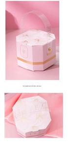 Detail of pink hexagonal wedding candy box with golden leaf patterns and clear handles
