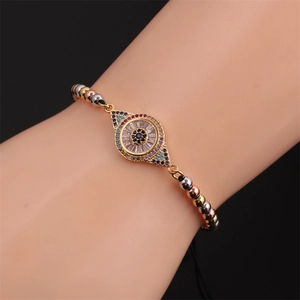 Détail du bracelet tressé mauvais œil avec zircons colorés et perles tricolores