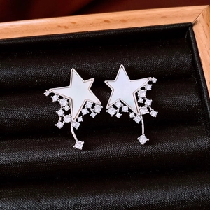Detailed close-up of star-shaped earrings with mother-of-pearl and zircon tassels