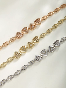Detailed macro view of geometric triangle link bracelets in rose gold, gold and silver finishes