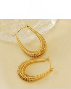 Close-up of gold 18K plated U-shaped hoop earrings with spiral twisted metal texture