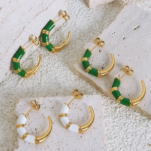 Golden C-shaped bamboo style stud earrings with green and white enamel on stone