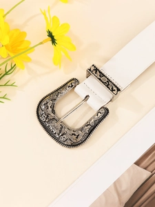 Close-up of vintage western white belt with ornate floral engraved silver buckle