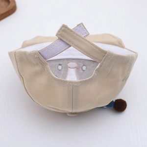 Detail of adjustable velcro strap and soft cotton lining on a beige baby penguin hat