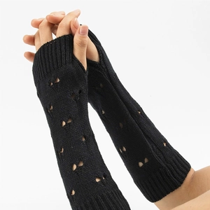 Detail of black knitted arm warmers featuring heart-shaped cutout pattern for women