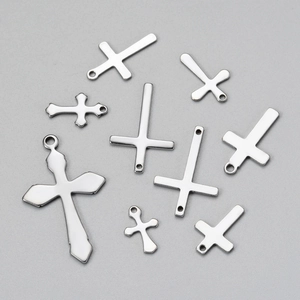 Flat lay of various silver stainless steel cross pendants in multiple sizes and styles