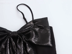 Détail du nœud géant à paillettes sur un haut court noir sexy à bretelles