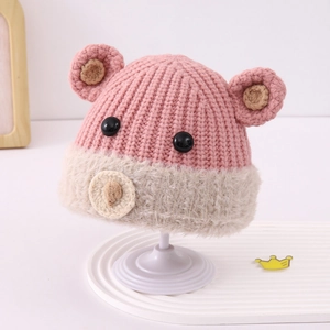 Dettaglio della trama a maglia rosa e bordo in pelliccia beige del cappello da orso