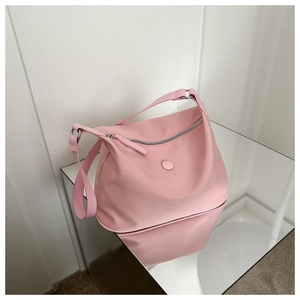 Vue détaillée du sac demi-lune en nylon rose avec boucles argentées et fermeture éclair