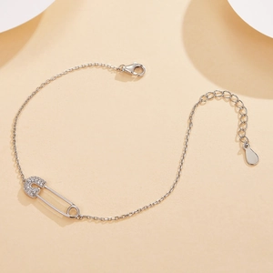 Detailed close-up of a silver safety pin bracelet with cubic zirconia in pave setting