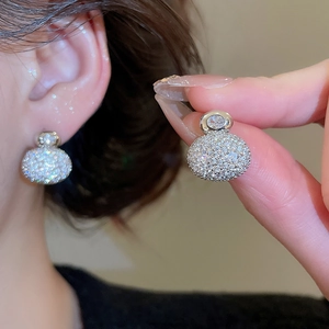 Macro detail of gold plated cubic zirconia double ball earrings with pavé setting