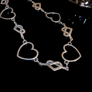Silver hollow heart-shaped chain belt with intricate interlocking metallic links