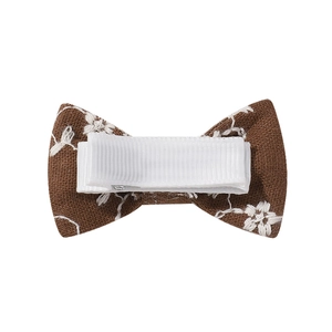 Brown fabric bow hair clip with white floral embroidery and ribbon-wrapped metal alligator clip