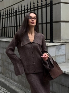 Detail of dark brown knit cardigan with v-neck and matching skirt on model outdoors