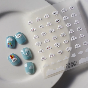 Macro detail of 5D embossed white cloud nail stickers with cute facial expressions