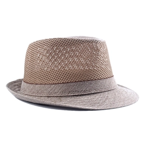 Detailed close-up of breathable hexagonal mesh crown on light brown men's straw fedora hat