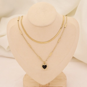 Détail du collier double rang doré avec chaîne serpent et pendentif cœur noir