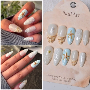 Detail of ocean-themed press-on nails with 3D shell texture, starfish, and pearls