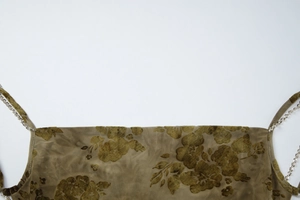 Detailed view of tie-dye velvet dress featuring vintage floral print and metal chain strap