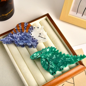 Detail of dinosaur hair claws in acetate with triceratops and stegosaurus designs