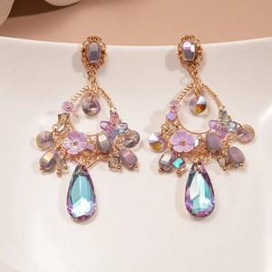 Detail of vintage drop earrings with purple resin flowers and iridescent crystals on white