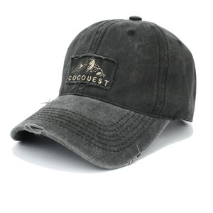 Close-up of vintage washed baseball cap featuring mountain patch embroidery and distressed details