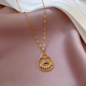 Detailed view of evil eye teardrop pendant with blue stone on silk fabric