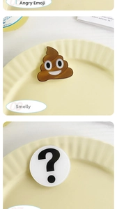 Close-up of funny acrylic emoji hair clips with poop and question mark icons