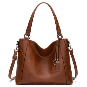 Detail of caramel brown faux leather tote bag with pebble texture and adjustable strap