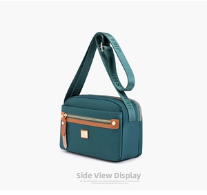Macro shot of teal nylon crossbody bag with leather trim and wide jacquard shoulder strap
