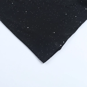 Détail du tissu noir avec paillettes argentées effet ciel étoilé sur une robe de soirée