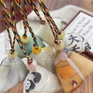 Macro detail of traditional zongzi sachet pendants with colorful braided silk ropes