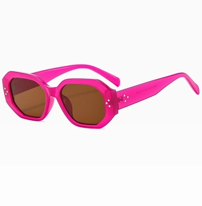 Detail shot of pink geometric sunglasses with brown lenses and metallic rivet hinges