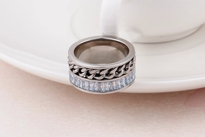 Detail of silver stainless steel ring with Cuban chain texture and rectangular zircon