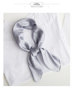 Macro shot of grey satin scarf styled on a white T-shirt showing glossy texture