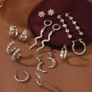 Set de pendientes plateados con circonitas, formas de serpiente y luna elegantes