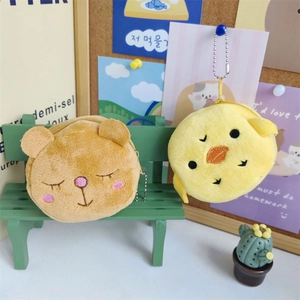 Cute plush bear and chick coin purses with keychains on a mini green decorative bench