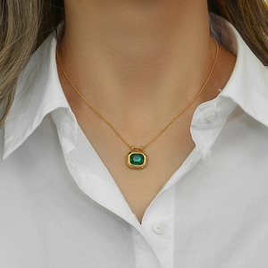 Detail of 18K gold plated necklace with an emerald green square zircon pendant