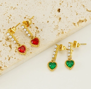 Detailed close-up of heart-shaped zircon earrings with pearls and gold plating