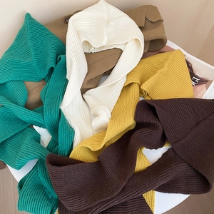 Flat lay of ribbed knit balaclava hoodies in multiple colors on a white table