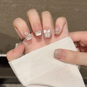 Pink gradient press-on nails with 3D bows, pearls, and French style nail art tips