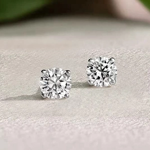 Macro shot of round brilliant cut diamond studs in classic four-prong sterling silver setting