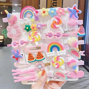 Close-up of colorful cartoon hair clips set featuring rainbow and candy shapes on a card